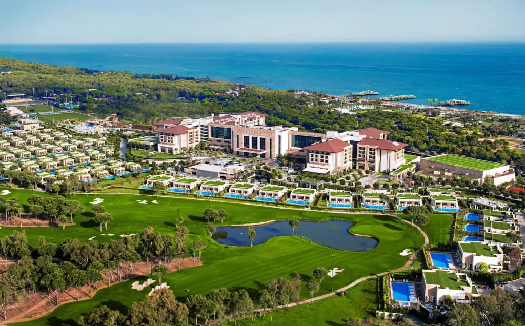 Luftaufnahme des Regnum The Crown Belek mit Golfplatz, privaten Poolvillen und Blick auf das Mittelmeer