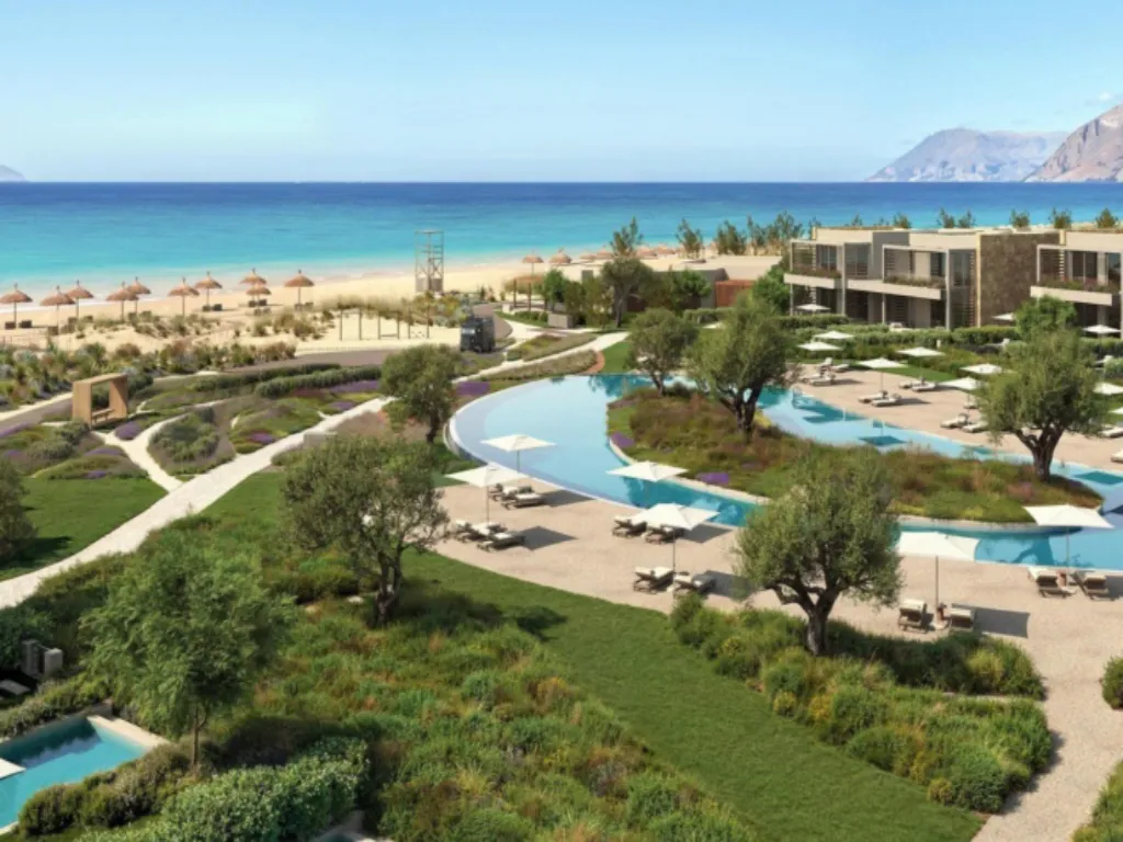 Panoramablick auf Poolanlage und Strand des Ikos Kissamos auf Kreta mit mediterraner Gartenlandschaft