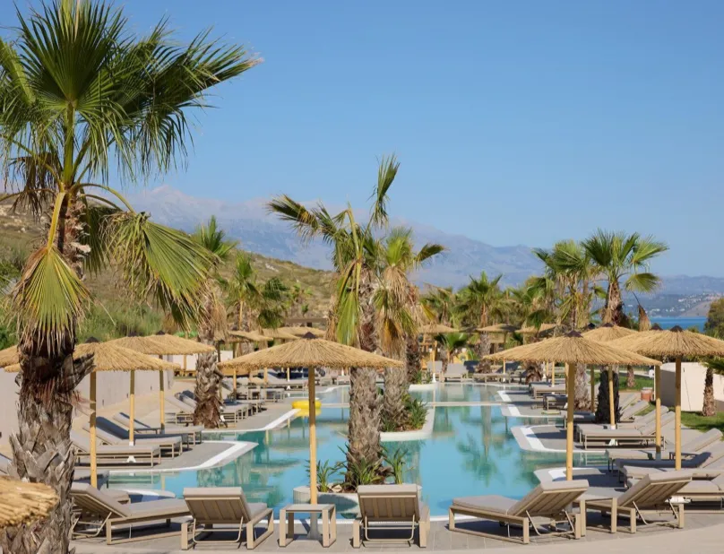 Poolbereich mit Palmen im Oros Luxury Beach Resort auf Kreta