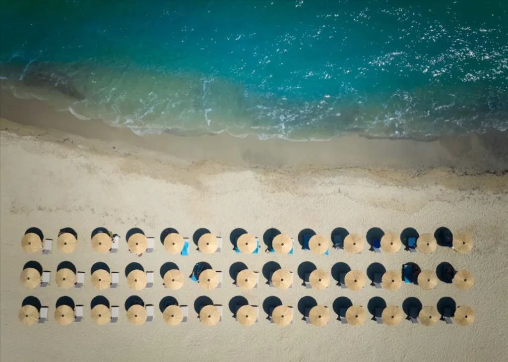 Strandbereich des Oros Luxury Beach Resort auf Kreta mit Sonnenschirmen und türkisblauem Meer