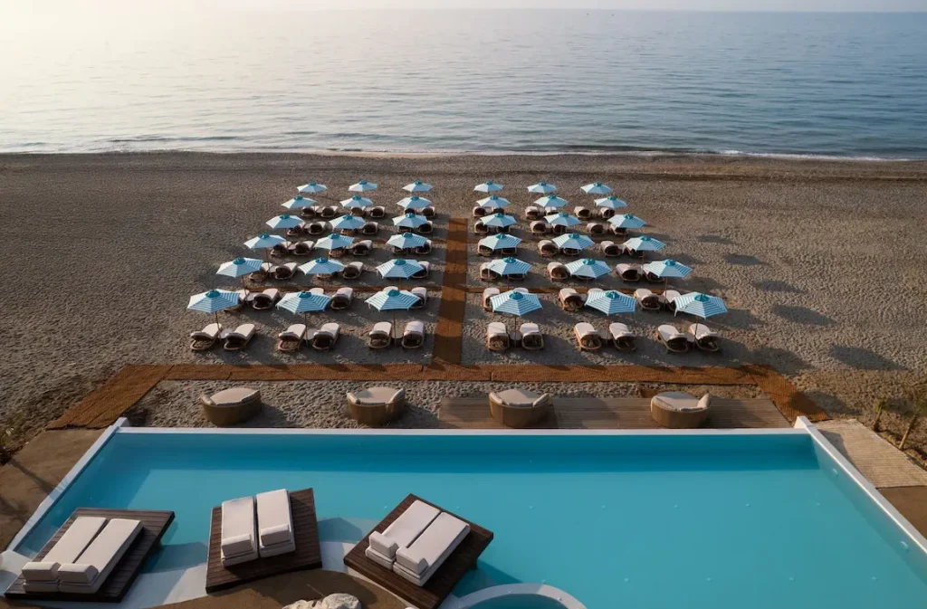 Infinity-Pool und Strandbereich des UZENIE All Suites Boutique Resort in Adelianos Kambos auf Kreta