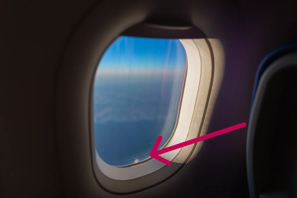 Flugzeugfenster mit kleinem Loch für den Druckausgleich in der Kabine