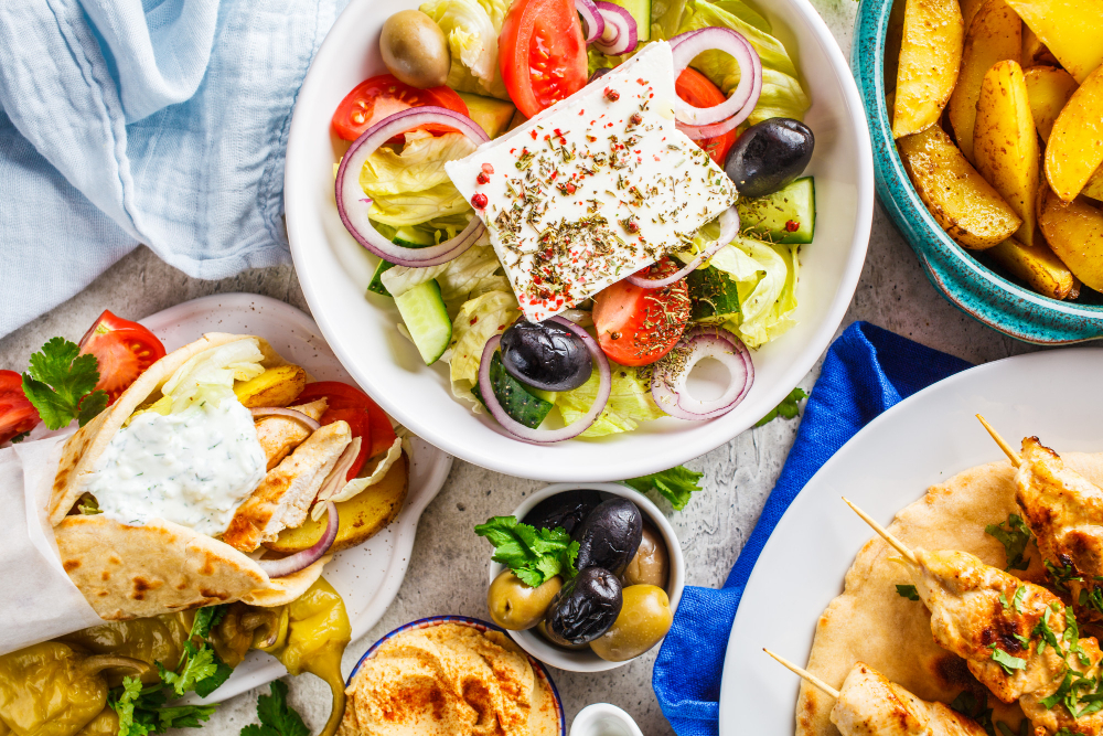 Griechische Spezialitäten mit Salat, Feta, Oliven und Souvlaki – mediterrane Küche laut Taste Atlas