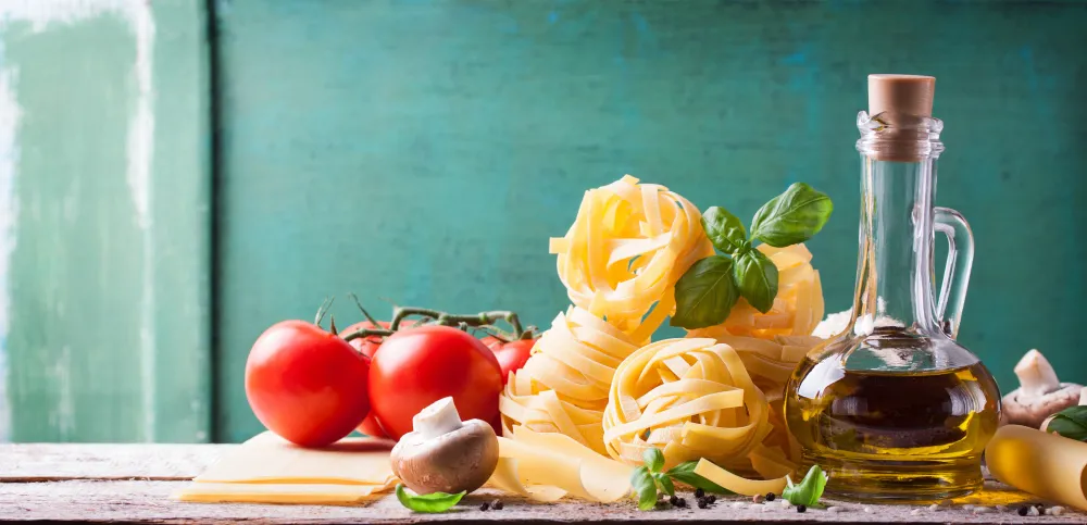 Italienische Küche mit Pasta, Tomaten, Basilikum, Olivenöl und Käse als typische Zutaten