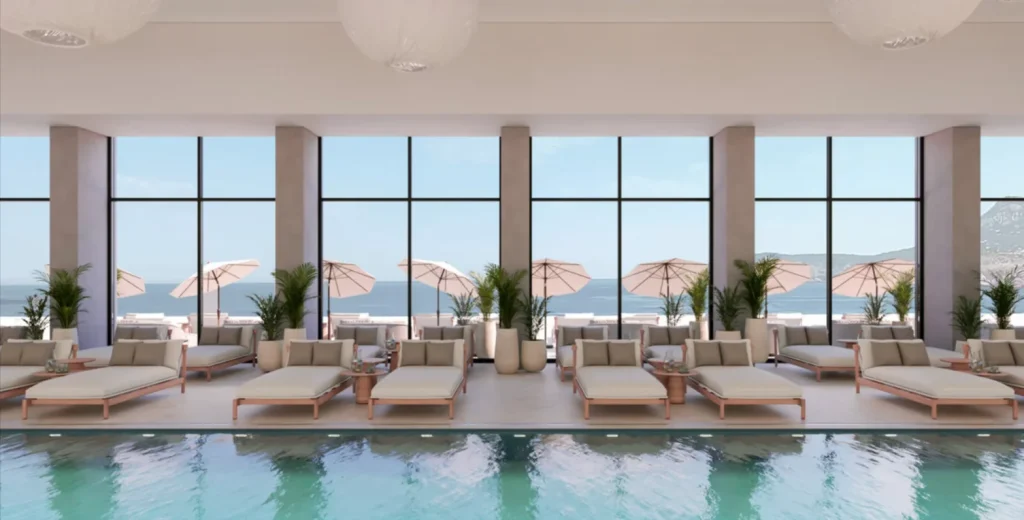 Innenpool im Iberostar Selection Montenegro mit Liegen, gro&szlig;en Panoramafenstern und Blick auf die Adriak&uuml;ste